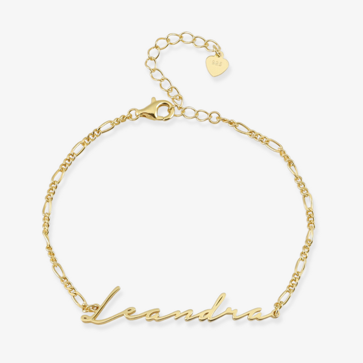 Gold 18K double-plated Figaro Signature Name Bracelet in stylish font with personalized name "Leandra" and adjustable chain.