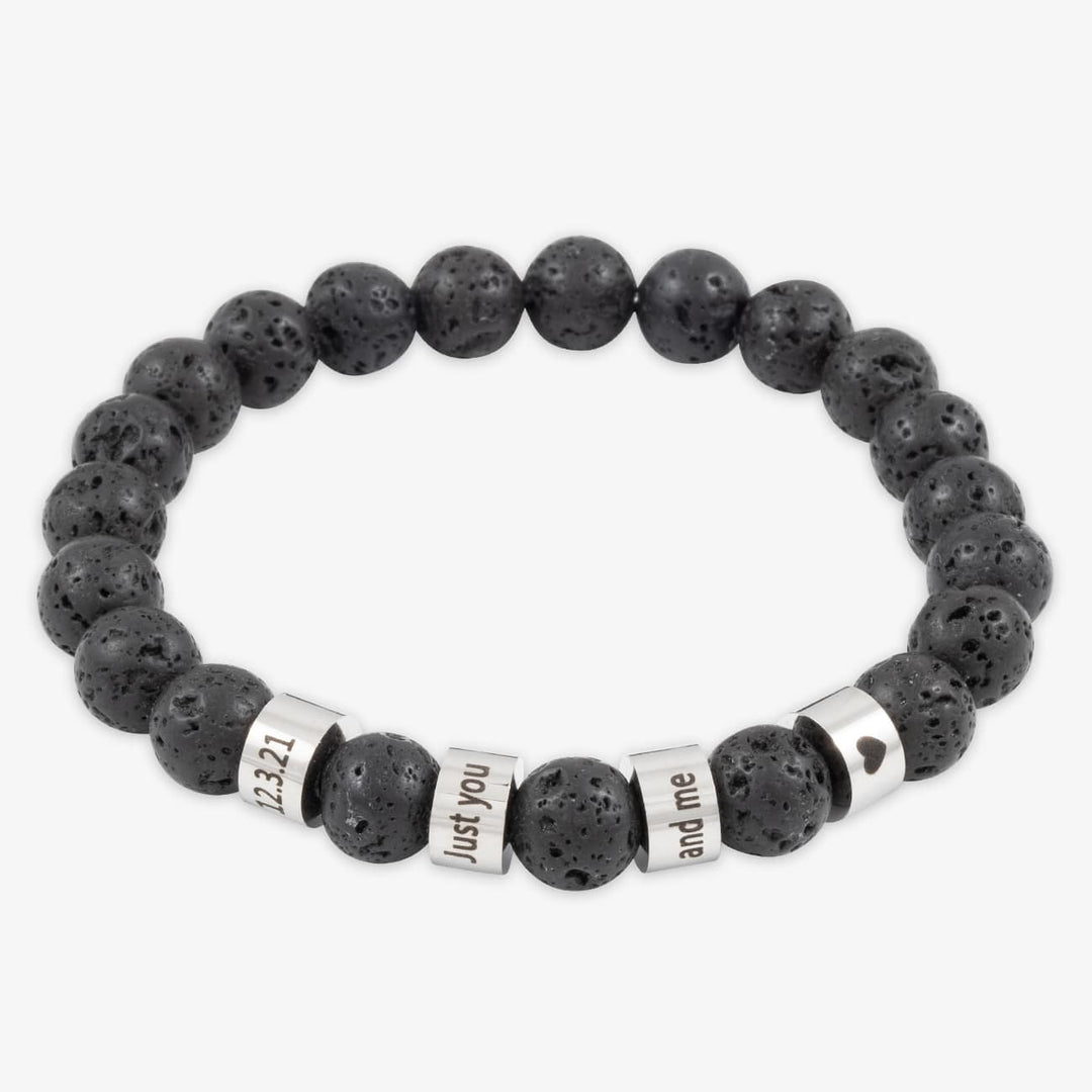 Black beaded bracelet with four engravable stainless steel rings on a white background