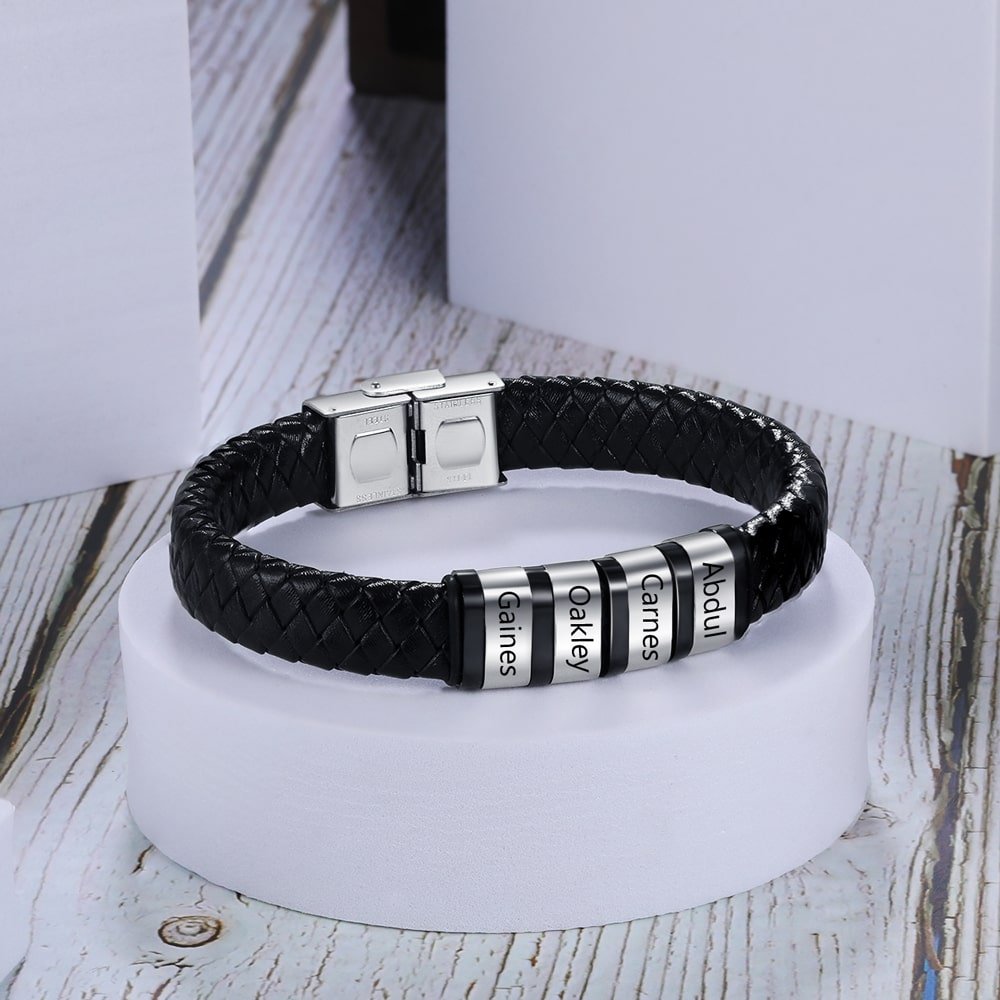 Customizable men's black faux leather bracelet with four engraved stainless steel rings, perfect for personalized inscriptions or dates