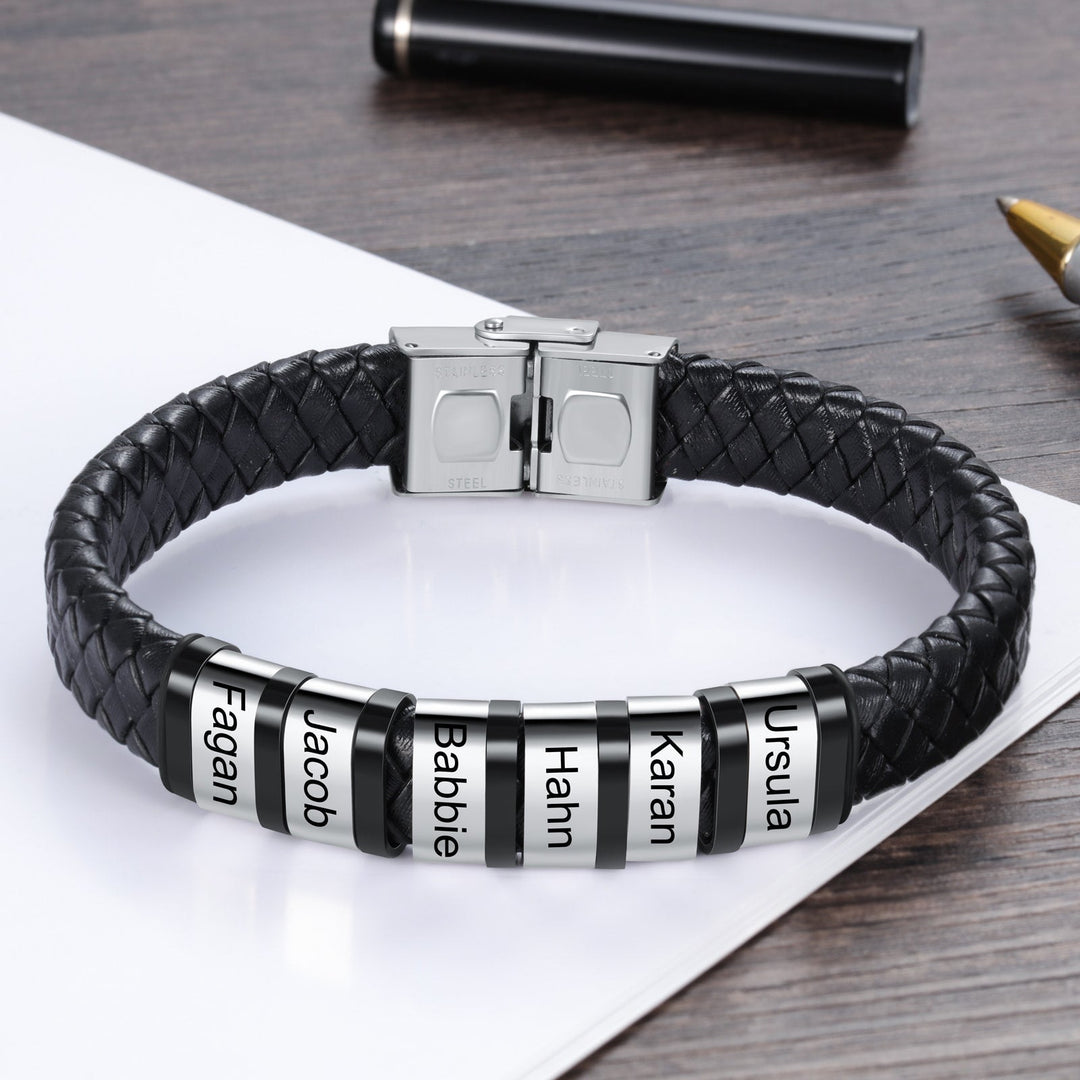 Customizable men's leather bracelet with 6 engraved names on stainless steel rings and black faux leather strap.