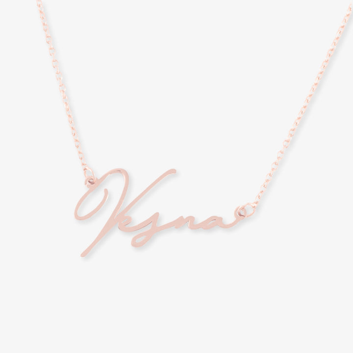 Personalized name necklace with extravagant script in rose gold, made of 925 sterling silver, displayed on a simple chain.