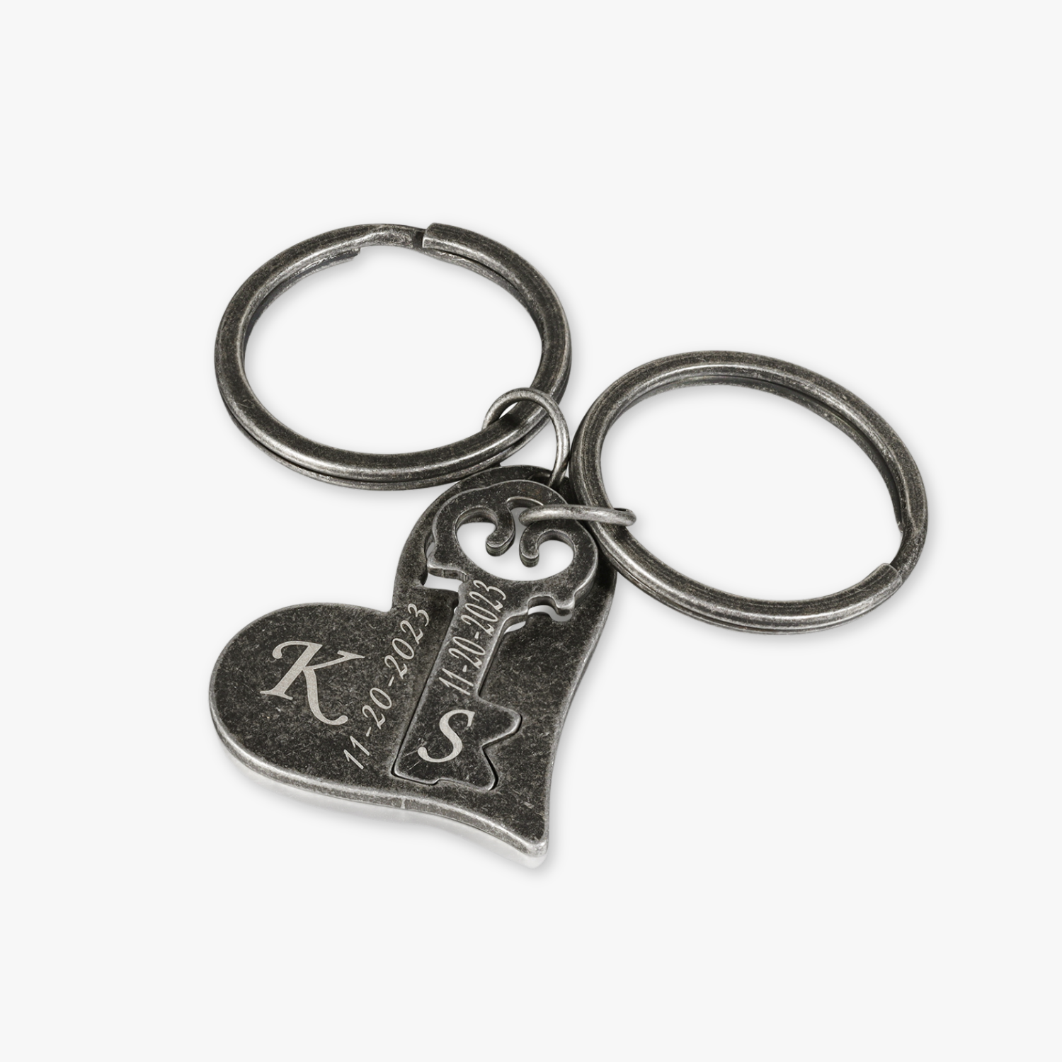 Personalized dark grey couple's keychain set with heart and key charms, custom engraved with initials K and S, and date 11-20-2023