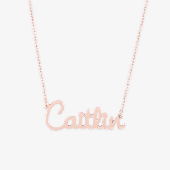 Elegant cursive name necklace in rose gold with the name "Caitlin" showcasing playful and elegant script.