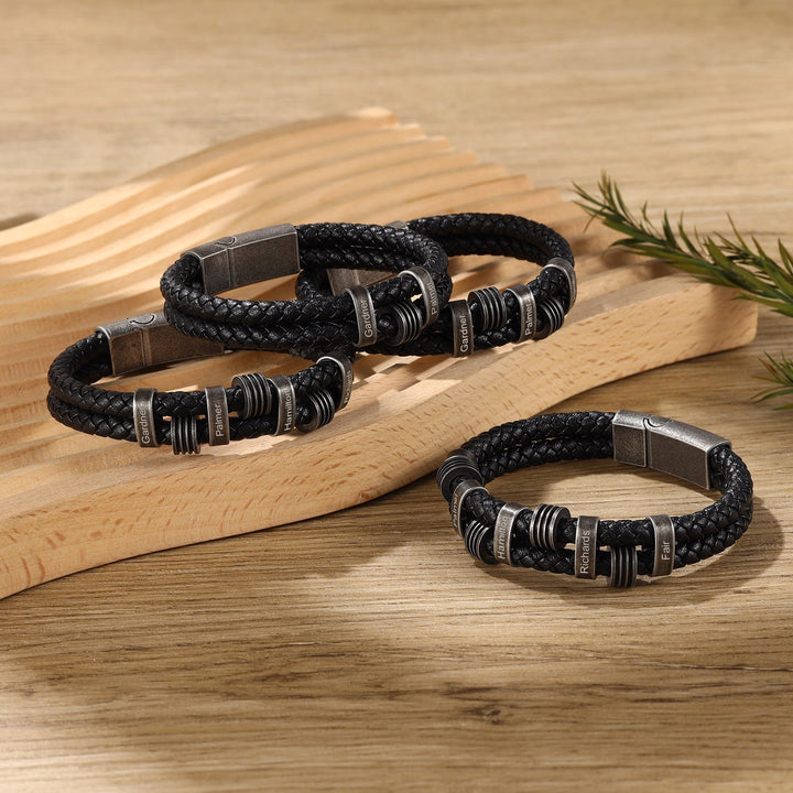 Personalized black braided leather bracelet with dark grey stainless steel rings, customizable with up to three engravings, 21.5cm size