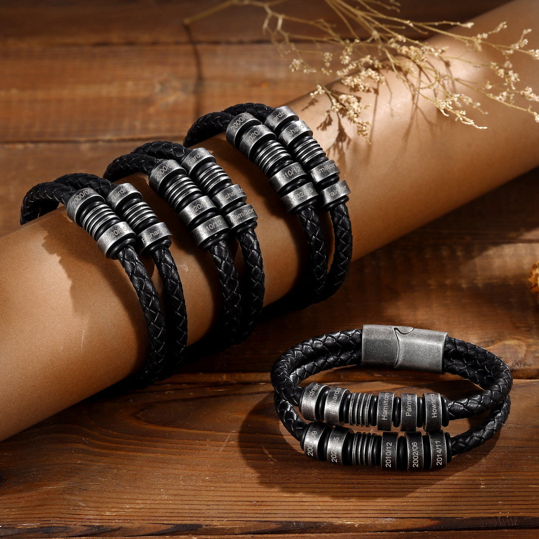 Black braided leather bracelet with four customizable engraving options, displayed on a wooden surface.