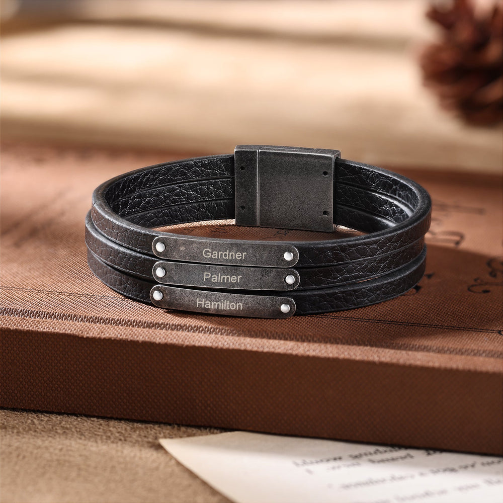 Customizable dark grey leather bracelet with three engravings on a book. Elegant and tailored for individuality. Made from high-quality leather and stainless steel.