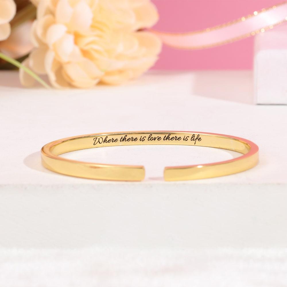 Thin engraved bracelet in gold color with the message "Where there is love there is life" displayed, perfect for personalizing.