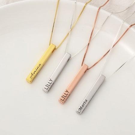 Quad-Engrave sterling bar necklaces in gold, silver, rose gold with personalized engravings on a white plate.