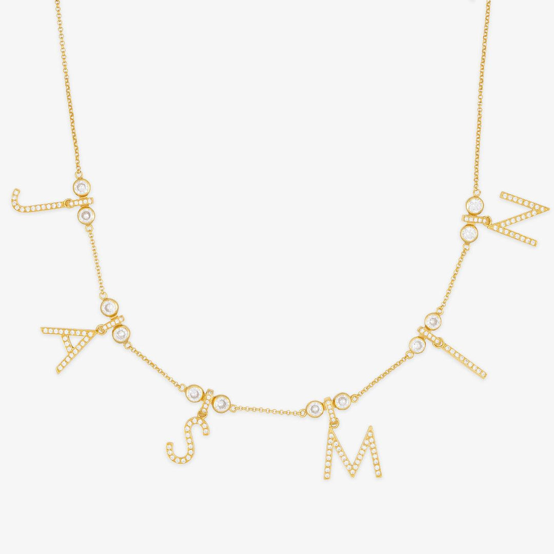 Luxurious gold initial necklace with zirconia stone letters, sparkling gems spelling out a name, elegant personalization jewelry piece.