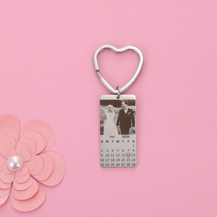 Personalized calendar photo keychain with heart-shaped pendant and engraved image on pink background.