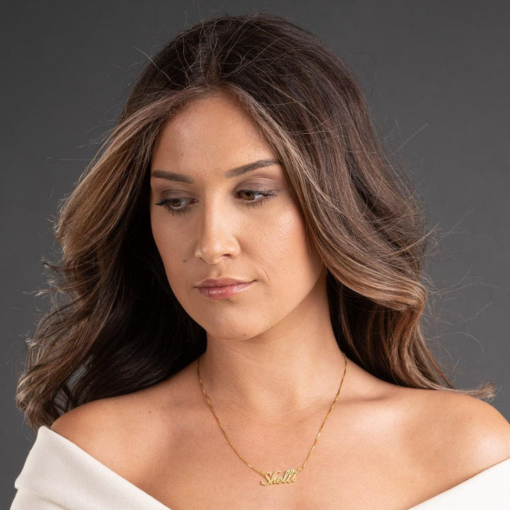 Woman wearing Shelli Style Name Necklace in 14 Karat Gold with stylish script font