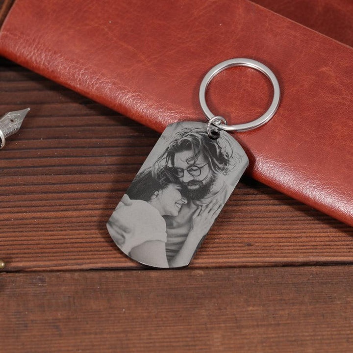 Personalized black photo keychain with custom engraving, featuring an engraved photo of a couple on a stainless steel pendant.