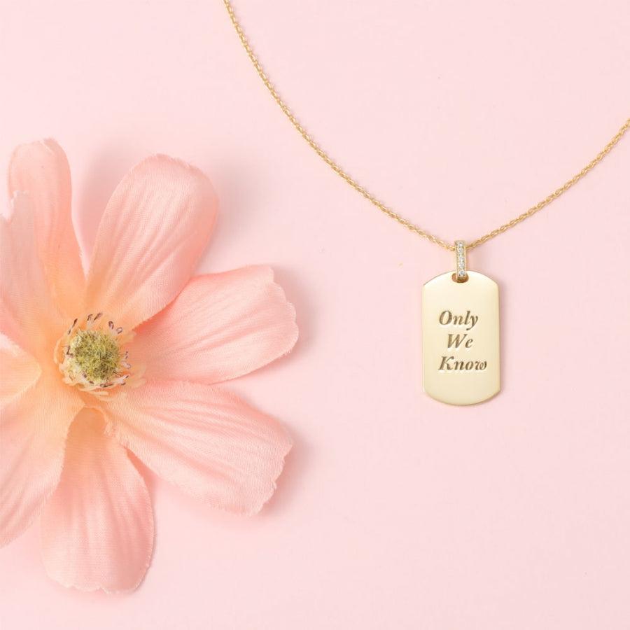 Shiny Radiance Personalized Necklace with engraved "Only We Know" message next to a pink flower on a soft pink background