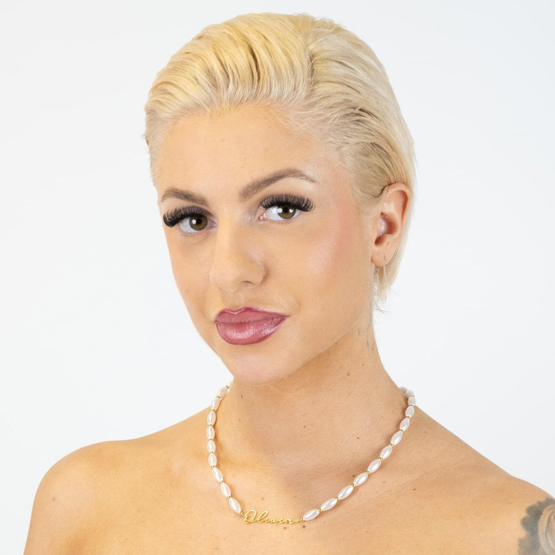 Woman wearing customizable pearl name necklace in signature script with oval pearls and 925 Sterling Silver.